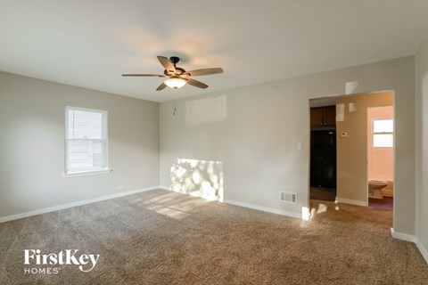 A spacious room with a ceiling fan and a window.