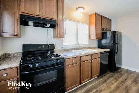 A kitchen with wooden cabinets and a black stove top oven.