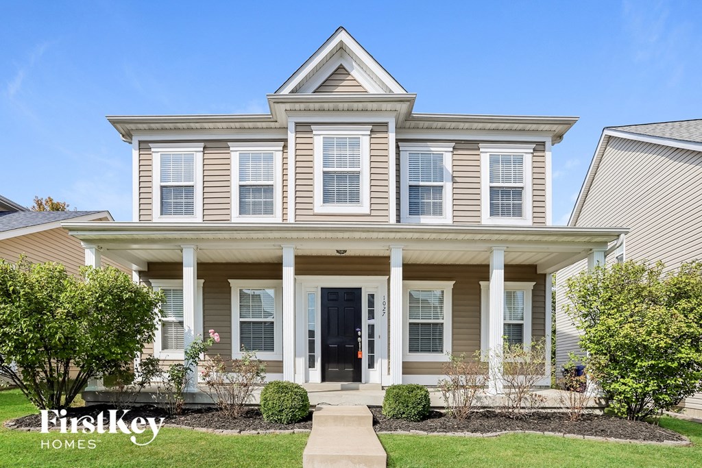 a white house with white columns and a black door