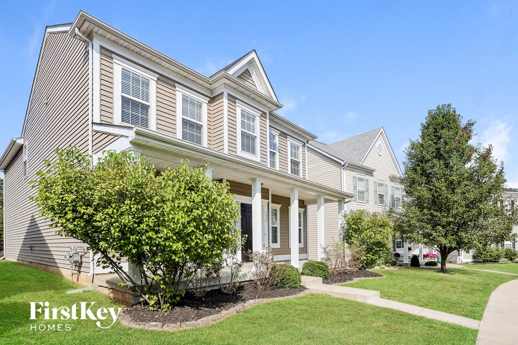 a house with a lawn and trees in front of it