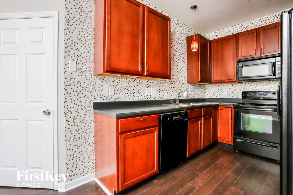 a kitchen with wooden cabinets and black appliances