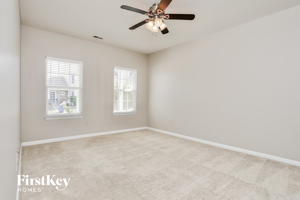 an empty room with a ceiling fan and a window