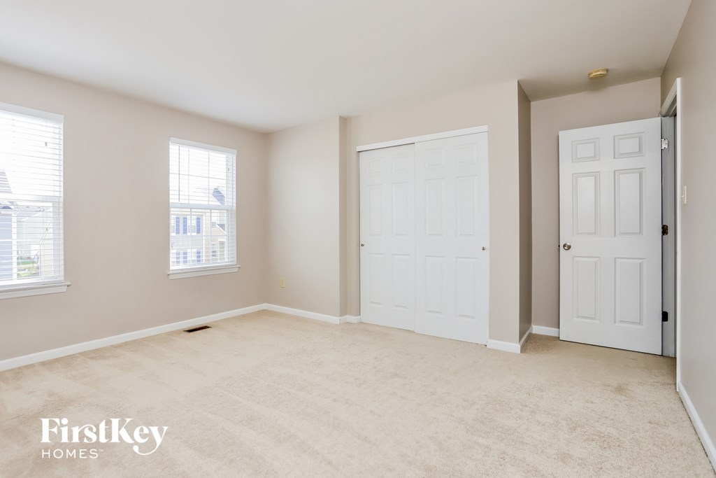 a bedroom with two white doors and a carpeted floor