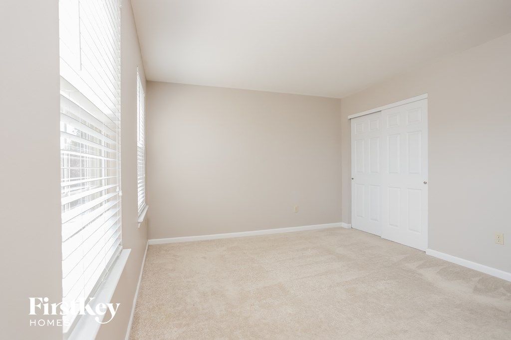 a bedroom with a large window and a white door
