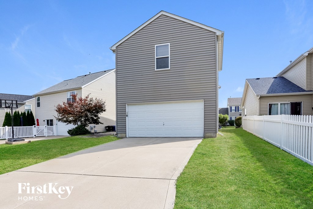 a with a white garage door and a lawn