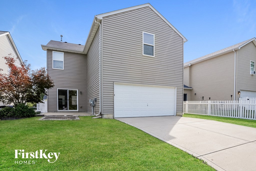 a gray house with a white garage door and a lawn