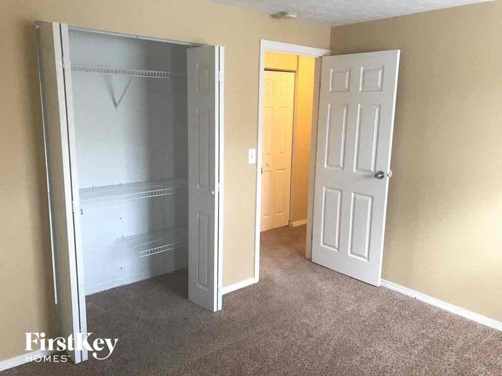 an empty bedroom with a closet and an open door