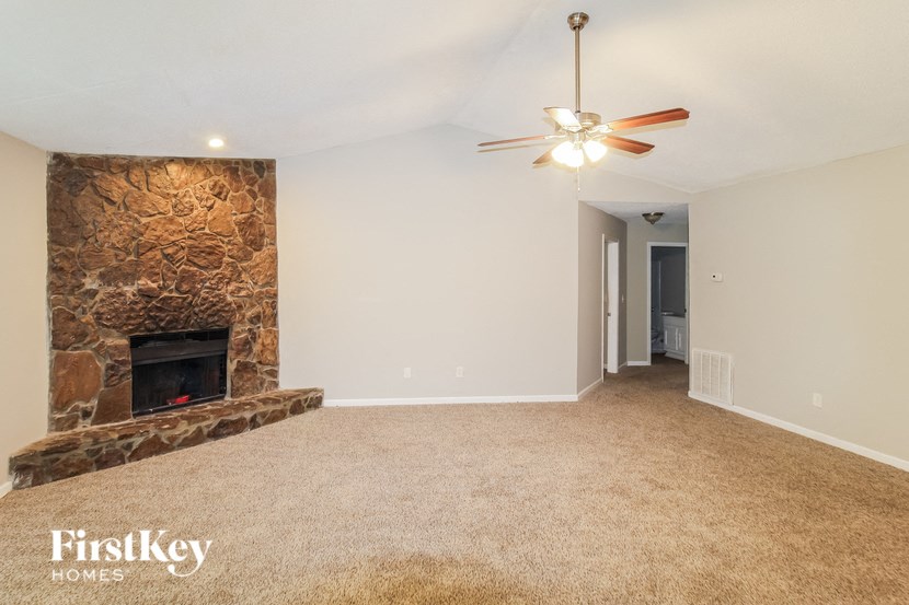 a living room with a fireplace and a ceiling fan