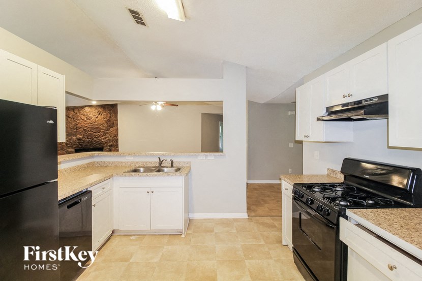 a kitchen with white cabinets and black appliances