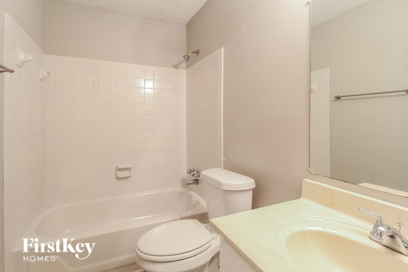 a white bathroom with a sink toilet and bath tub