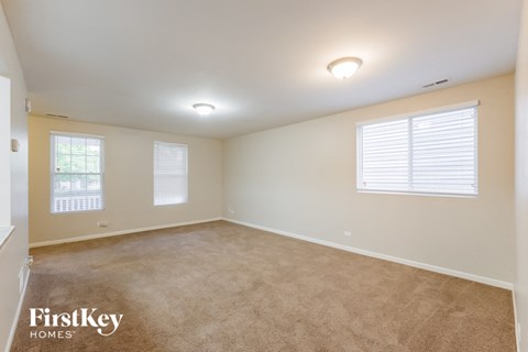 a bedroom with a carpeted floor and two windows