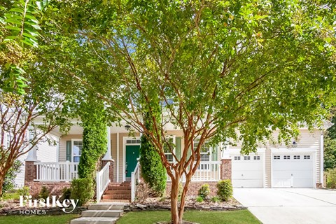 A tree in front of a house with the text "firstkey homes" on the bottom left.