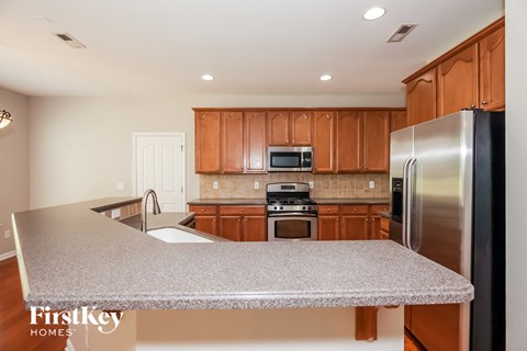 A kitchen with wooden cabinets and a stainless steel refrigerator.