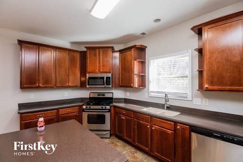A kitchen with wooden cabinets and a stove top oven.