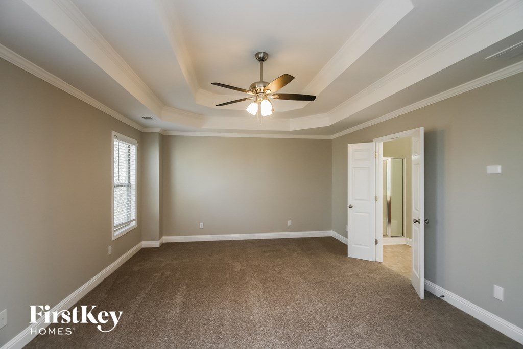 A spacious room with a ceiling fan and carpeted floor.