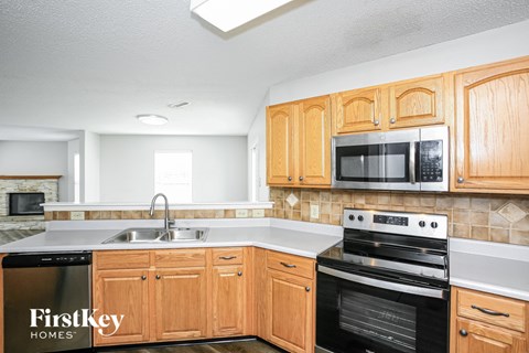 A kitchen with wooden cabinets and a stove top oven.