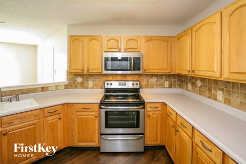 A kitchen with wooden cabinets and a stainless steel oven.
