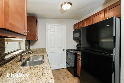a kitchen with black appliances and granite counter tops