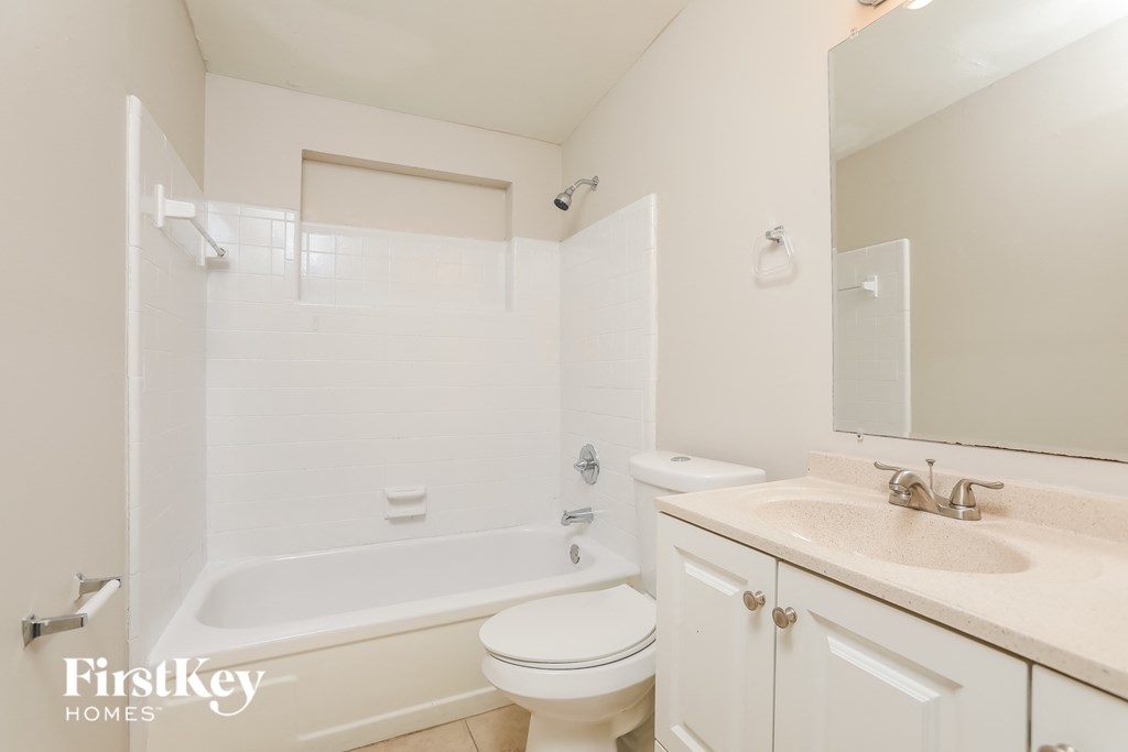 a white bathroom with a sink toilet and tub