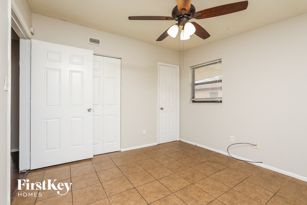 a living room with a ceiling fan and a tiled floor