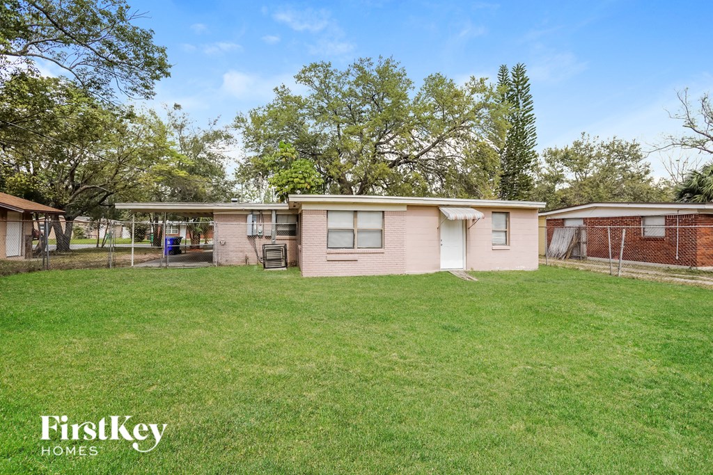 a small pink house with a yard and a chicken coop