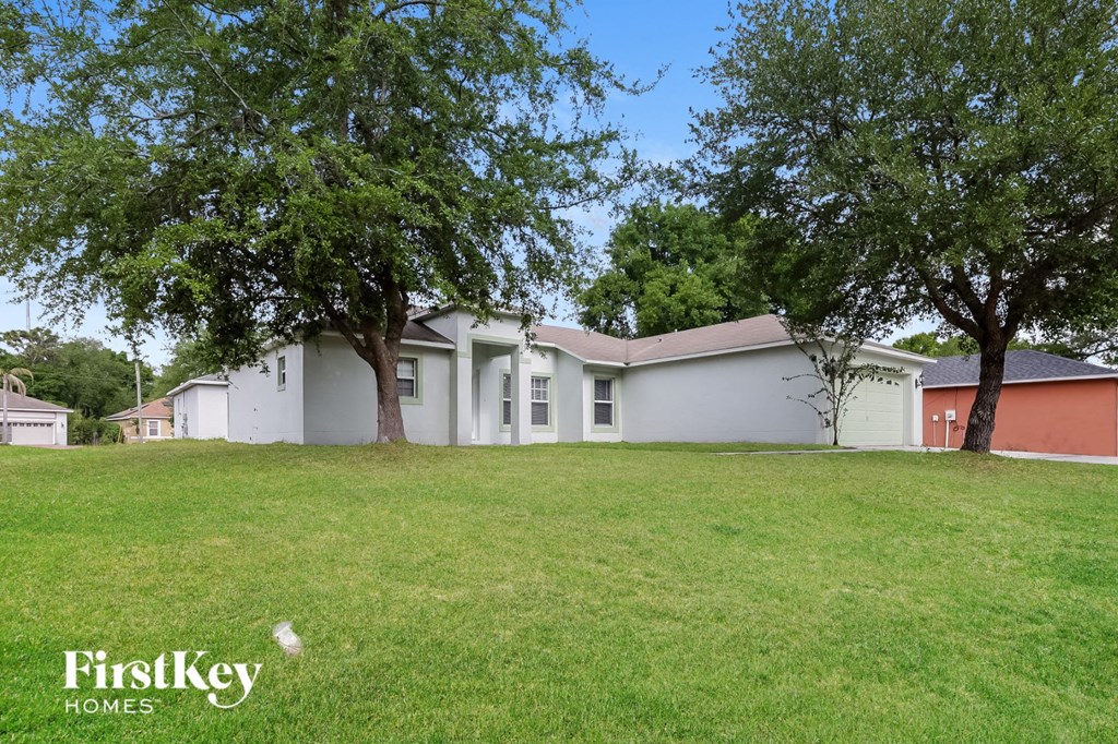 a white house with trees in the grass