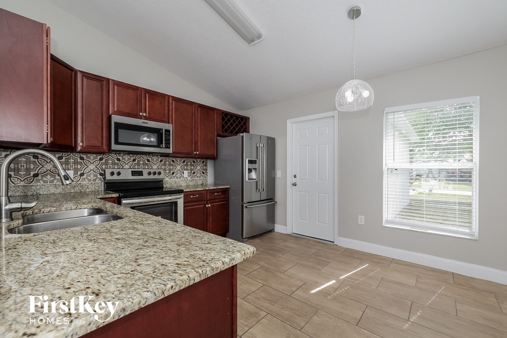 a kitchen with granite countertops and stainless steel appliances