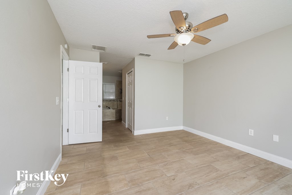 an empty living room with a ceiling fan