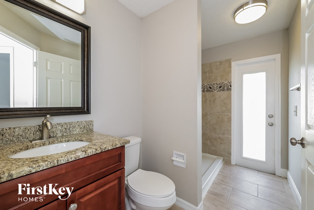 a bathroom with a toilet and a sink and a mirror