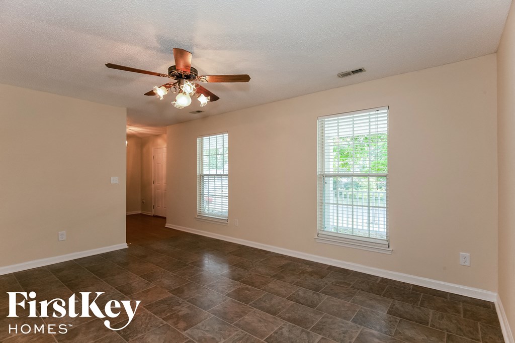 a living room with a ceiling fan and a large window