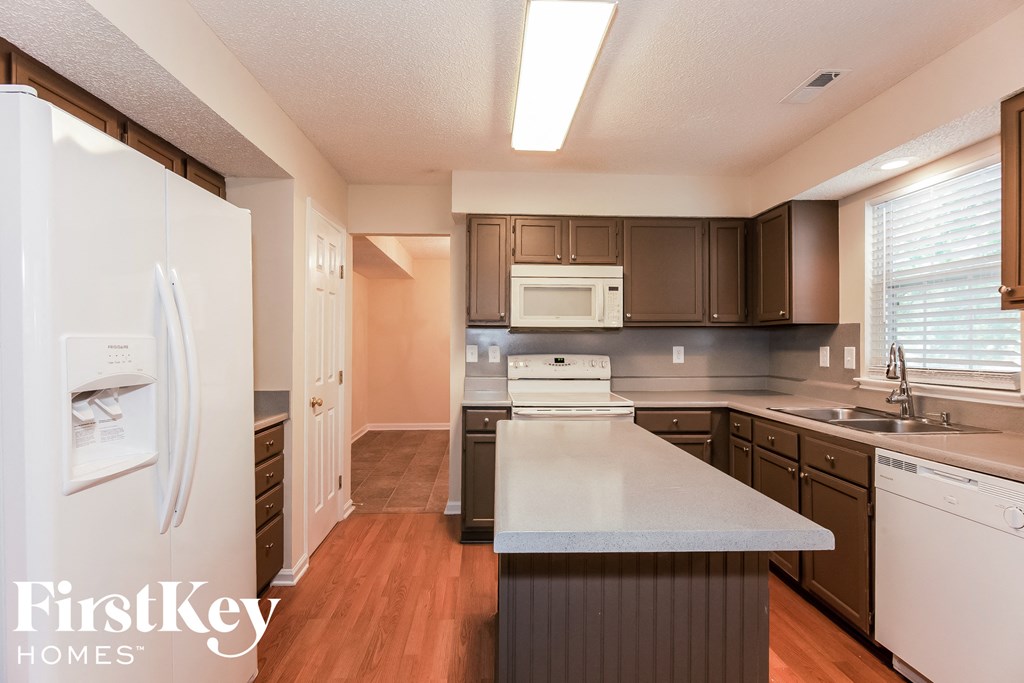 a kitchen with a white counter top and a refrigerator