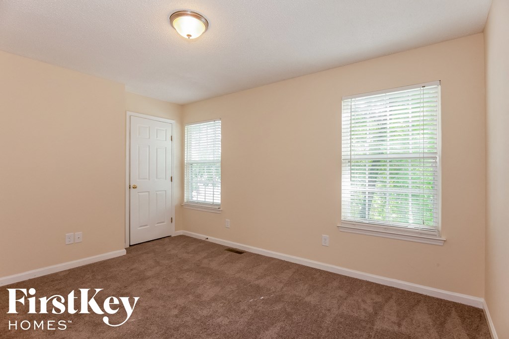 a bedroom with a carpeted floor and a white door
