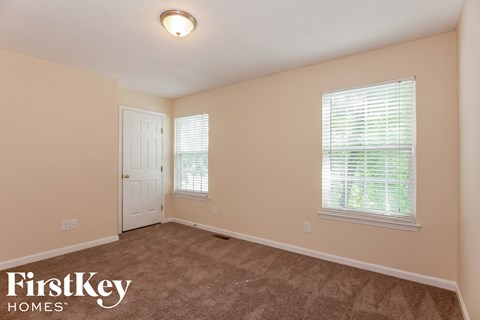 a bedroom with a carpeted floor and a white door
