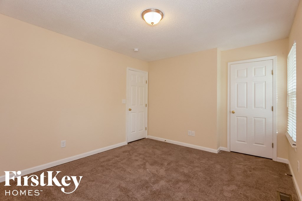 a bedroom with a carpeted floor and two doors