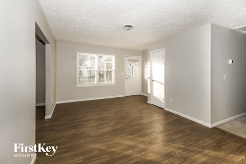 a living room with a hard wood floor and white walls