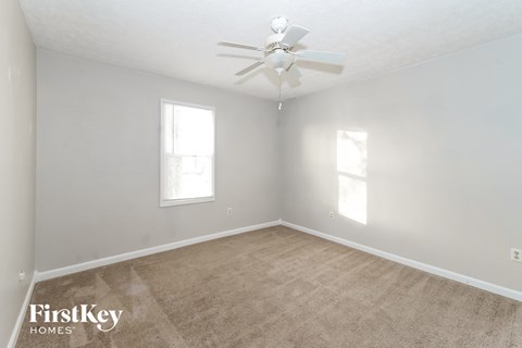 a bedroom with carpet and a ceiling fan