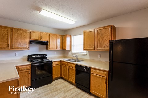 A kitchen with wooden cabinets and black appliances.