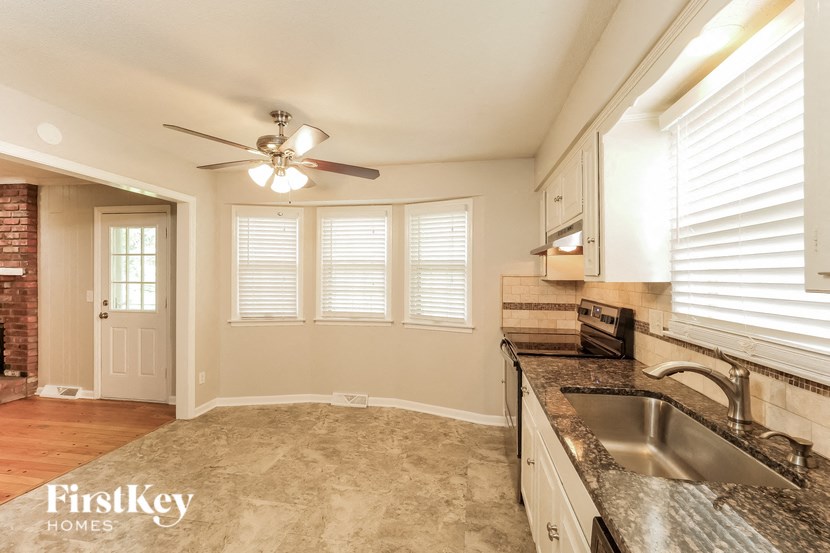 an empty kitchen with a sink and a ceiling fan