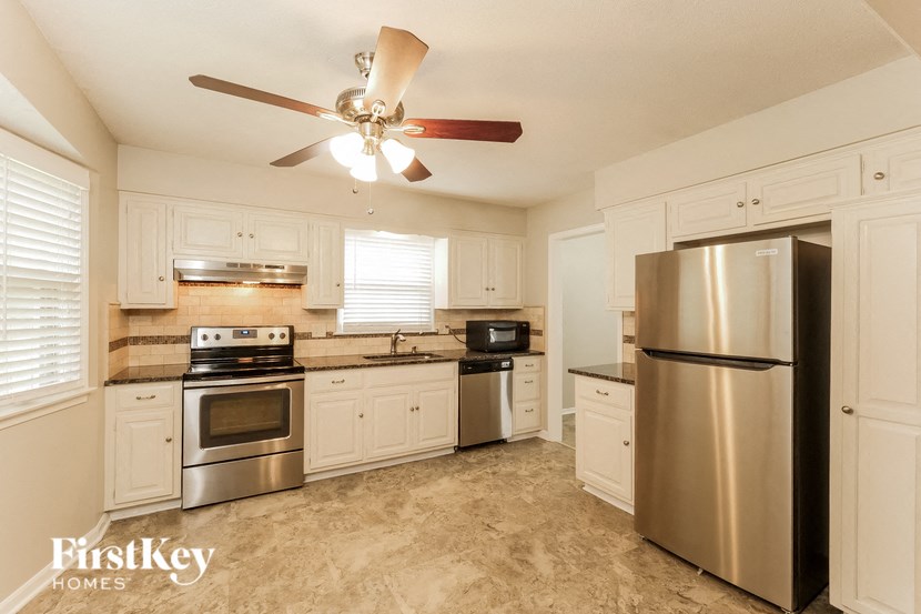 a kitchen with stainless steel appliances and white cabinets