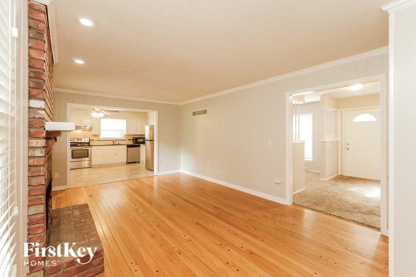 an empty living room and kitchen with wood floors
