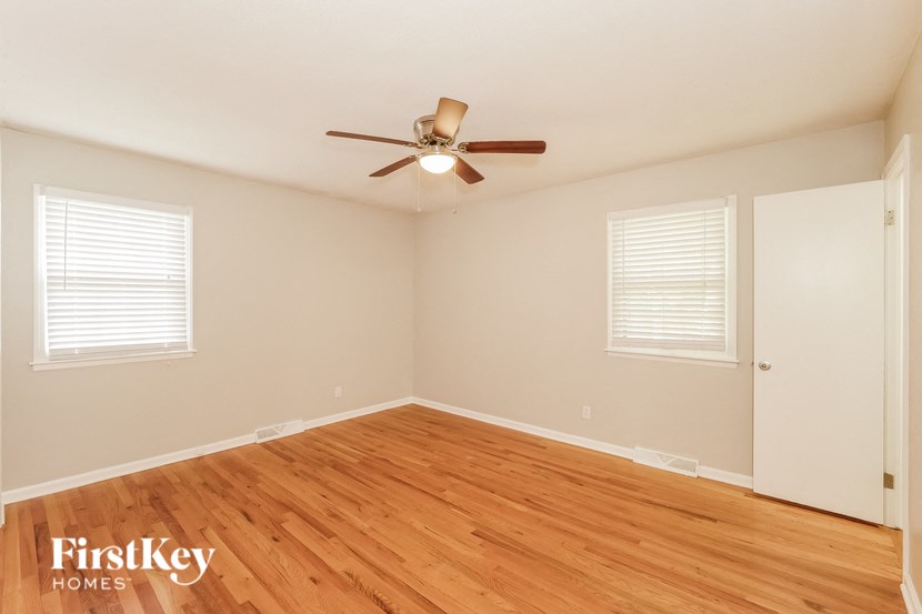 a living room with wood floors and a ceiling fan