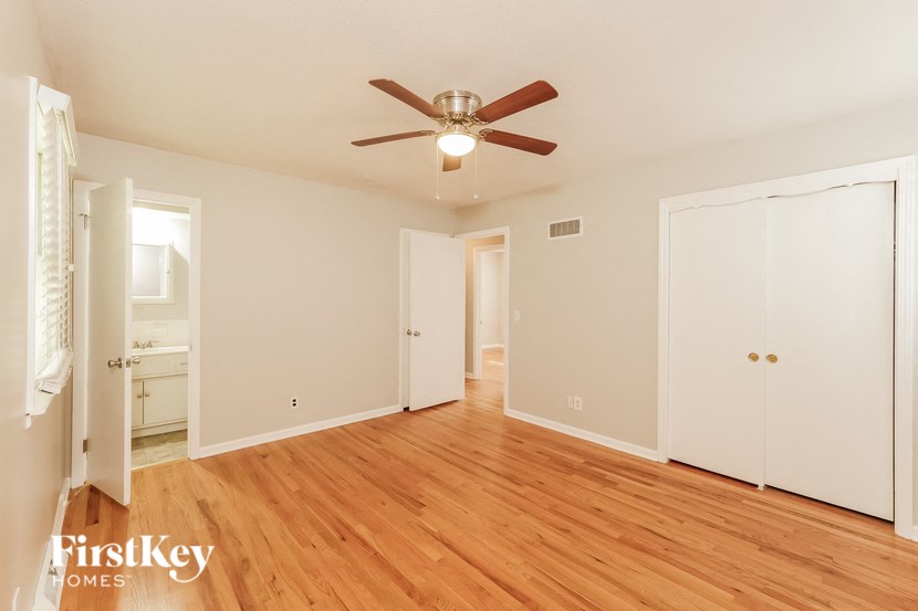 a living room with wood floors and a ceiling fan