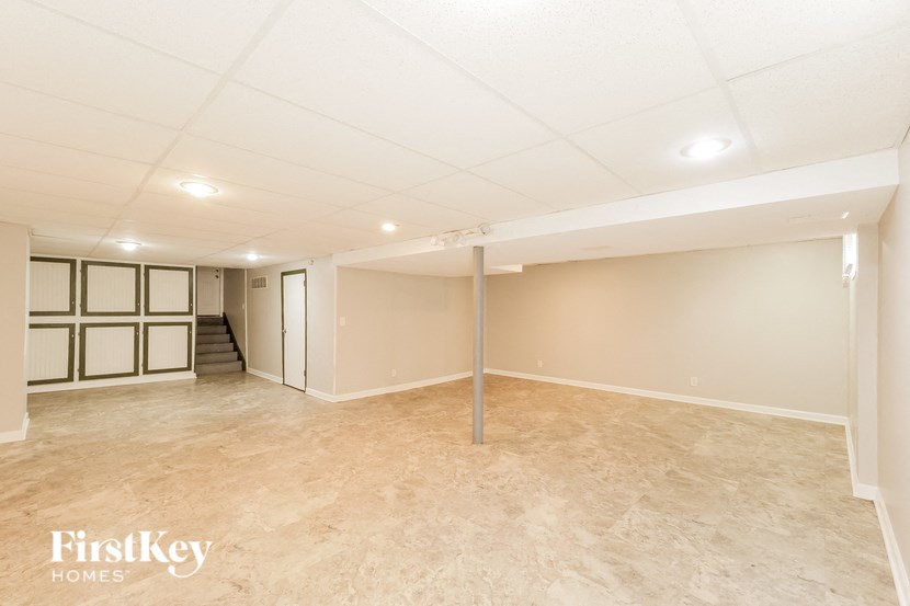 an empty basement with a large room and a staircase