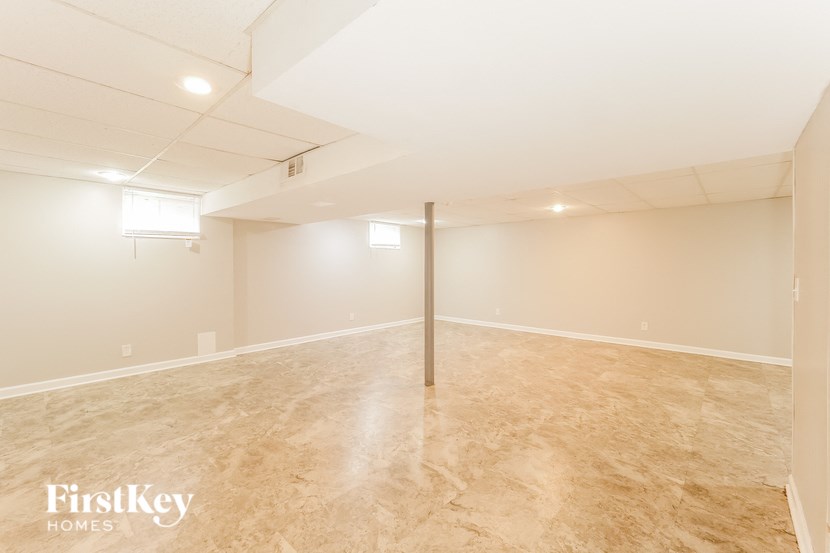an empty living room with a tile floor and white walls