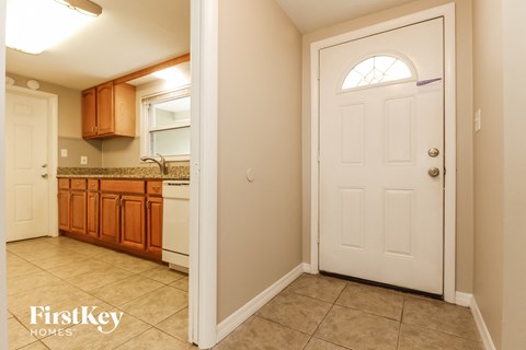A kitchen with wooden cabinets and a white door.