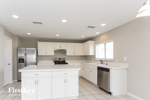 a large kitchen with white cabinets and stainless steel appliances