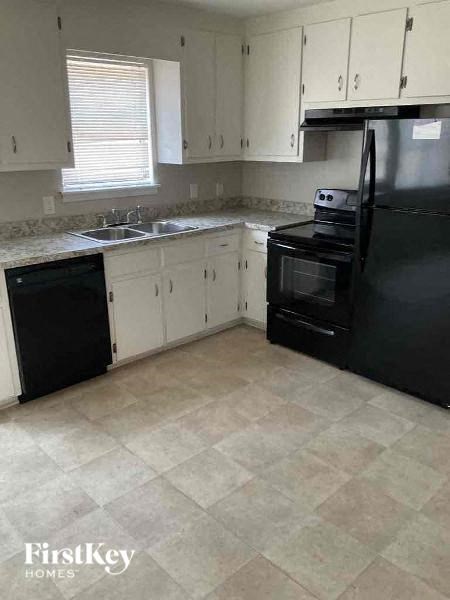 a kitchen with a black refrigerator and a sink