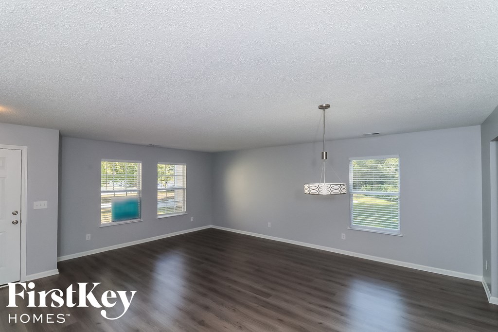 the spacious living room with wood flooring and windows