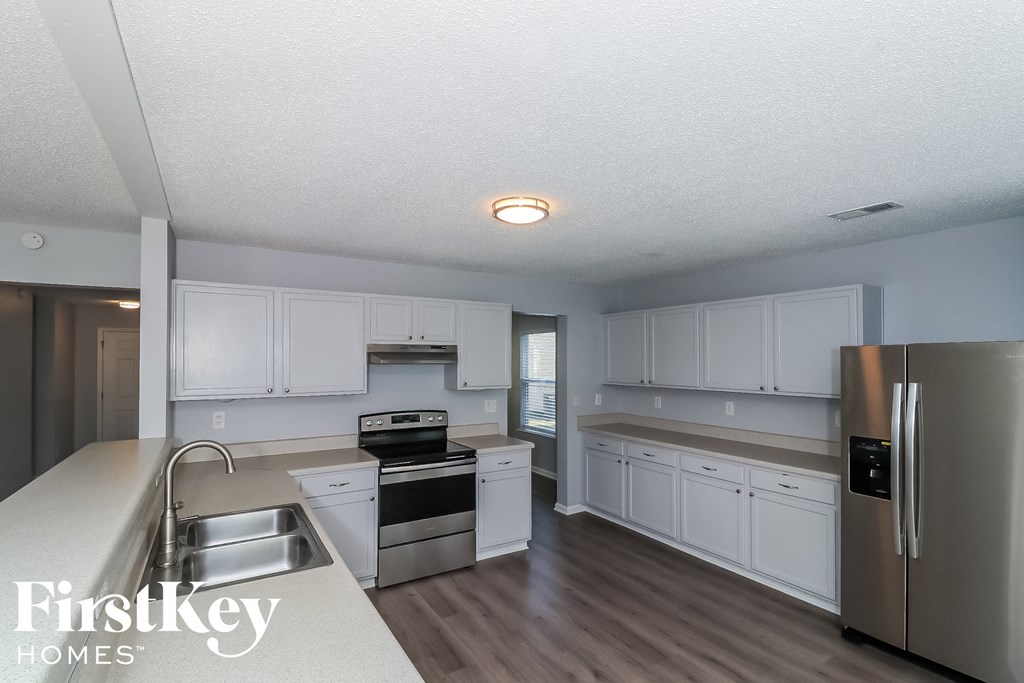 a kitchen with white cabinets and stainless steel appliances