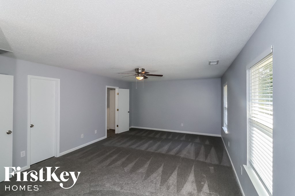 a living room with gray walls and a ceiling fan